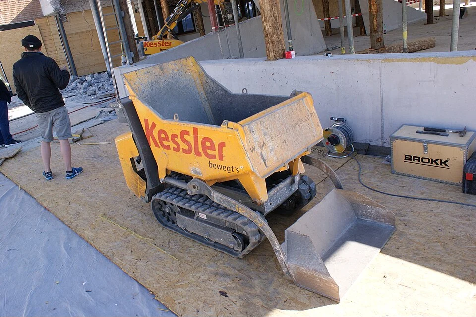 A small tracked dumper with a tipping skip.